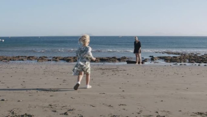 小女孩在海边向亲爱的妈妈跑去