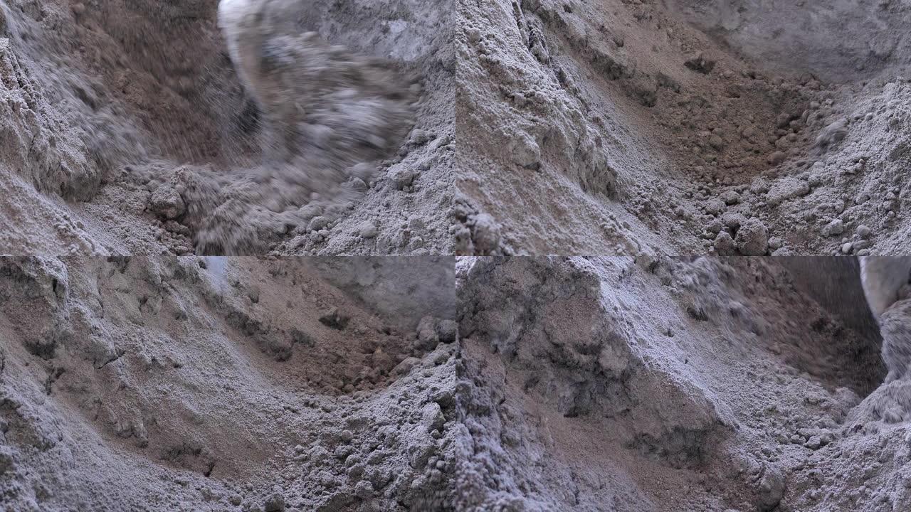建筑工人在建筑工地的混凝土搅拌水泥上加水和沙子