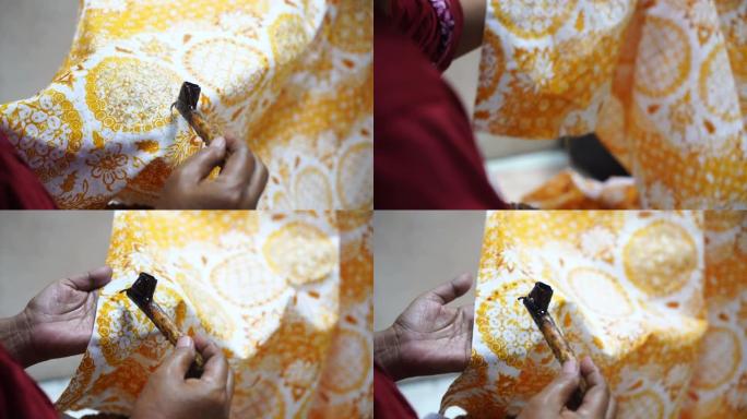 2020年12月22日印度尼西亚独奏: 在苏拉卡尔塔制作蜡染薄纱的传统倾斜，背景是彩色织物