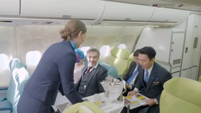 空姐在飞机上的航空公司工作人员在飞机上的客舱为商务舱的乘客提供食物和饮料。