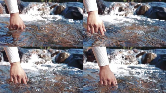 慢动作: 女人的手在瀑布或河湖度假旅行中摸水休息自然呼吸的气氛享受生活长周末4K UHD镜头。
