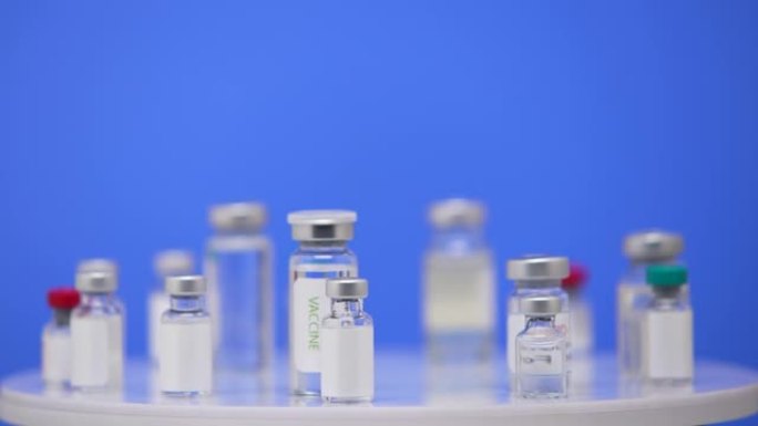 冠状病毒疫苗在安瓿关闭在实验室表蓝色背景。抗大流行新型冠状病毒肺炎的药理学药物。医疗疫苗从2019-