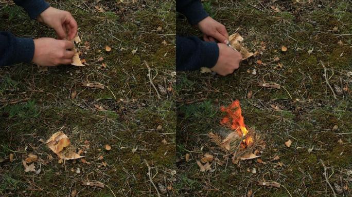 男人用火石在森林里点燃火