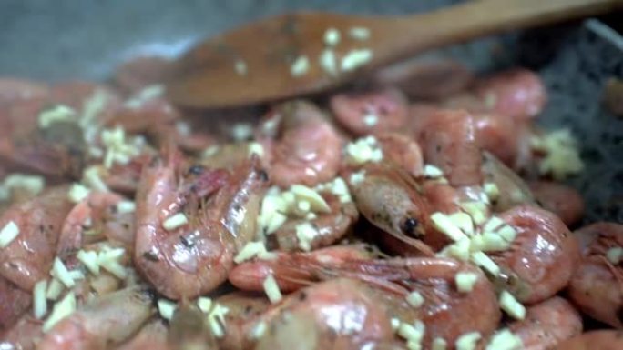 虾在平底锅里油炸。煮在贻贝上撒上切碎的大蒜。高清