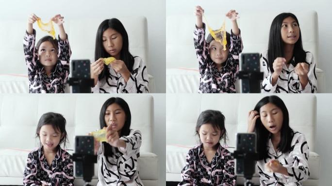 亚洲儿童Vlogging或Youtuber在家里的地板上评论水晶粘液，现代生活方式的概念。