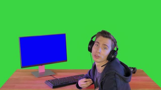 玩家在绿屏上与坐在PC监视器旁边的相机交谈，色度键