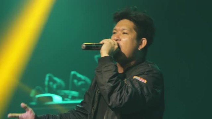 男歌手在新年晚会上的音乐会舞台上为游客唱歌。
