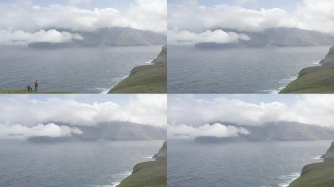 无人机飞越位于丹麦法罗群岛上的卡尔索伊岛 (Kalsoy Island) 上绿色崎cliff的悬崖山