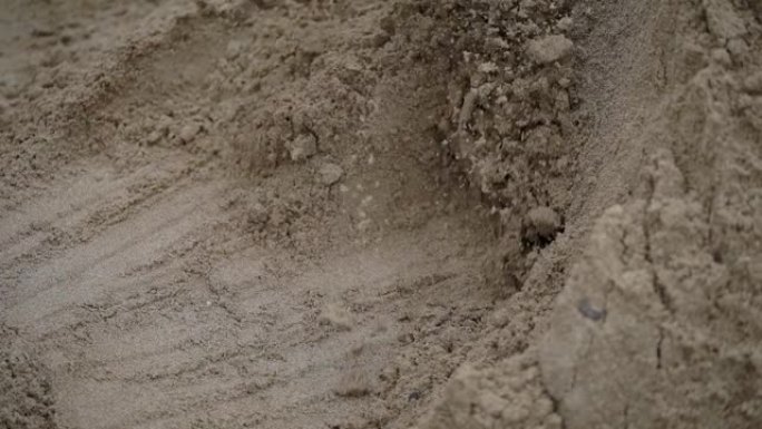 一名男子用轻塑料铲收集沙子用于建筑工作