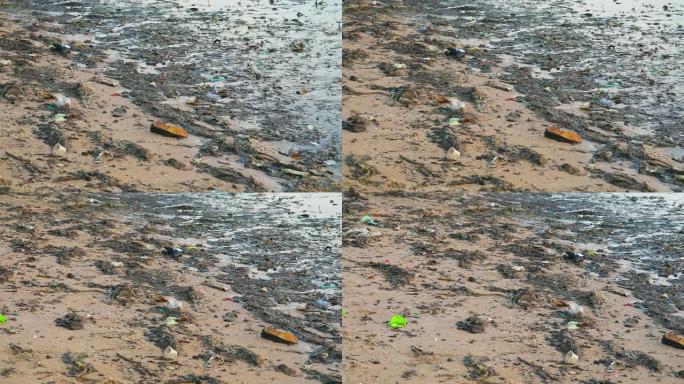 海岸上有泡沫和海藻的废物留在海滩上，海浪把它们吹入海中