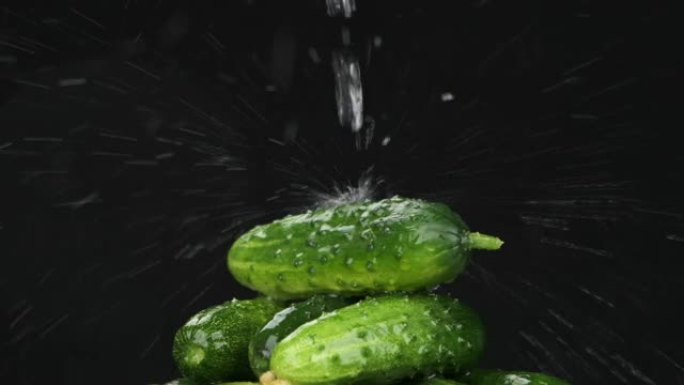 慢动作。水流落在一堆成熟的旋转的黄瓜上。