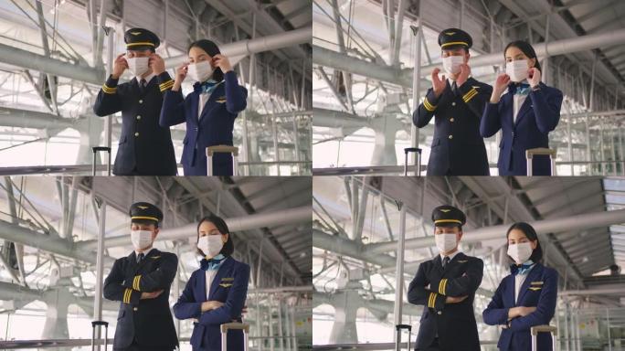 在COVID大流行期间，戴着口罩的客机飞行员和空姐在机场航站楼走到飞机上，以防止冠状病毒感染。航空运