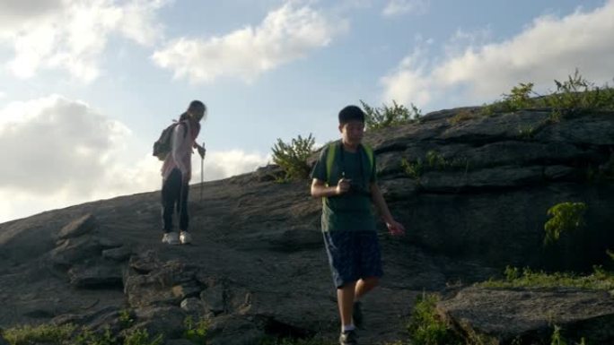 快乐的亚洲男孩和他的妹妹一起从山上走下来，积极的生活方式理念。