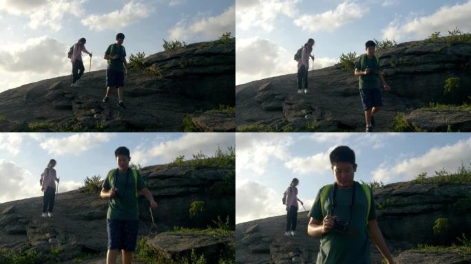快乐的亚洲男孩和他的妹妹一起从山上走下来，积极的生活方式理念。