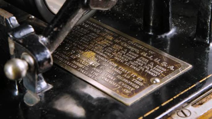 爱迪生复古留声机序列号的微距详细拍摄金属专利。老式机器再现听音乐的声音。特写。慢动作