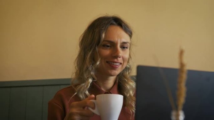 年轻女子喝一杯咖啡，在办公室外面工作。