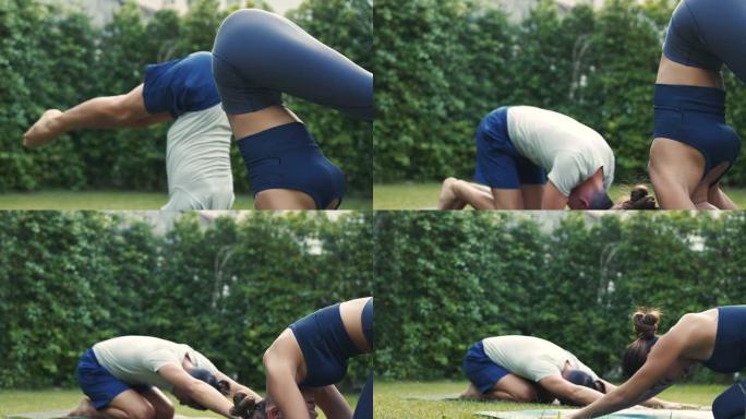 年轻的健身夫妇在房子的花园外面做一个孩子的瑜伽姿势。亚洲妇女和高加索男子在公园户外训练