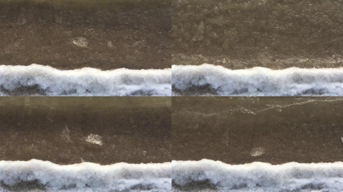海浪溅到岸上。白雪皑皑的海岸。特写。