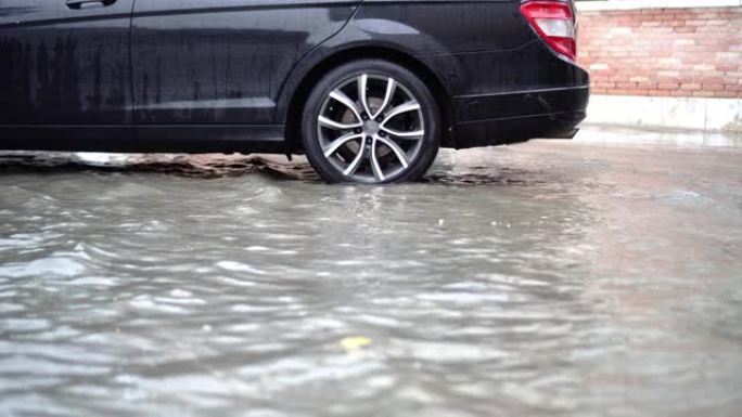 水淹没了现代黑色汽车的街道和停车场