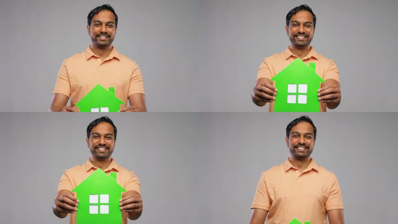 微笑的印度男子手持温室图标