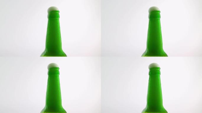 瓶中的泡沫啤酒，白色背景上的淡啤酒，啤酒瓶脖子上的泡沫流。