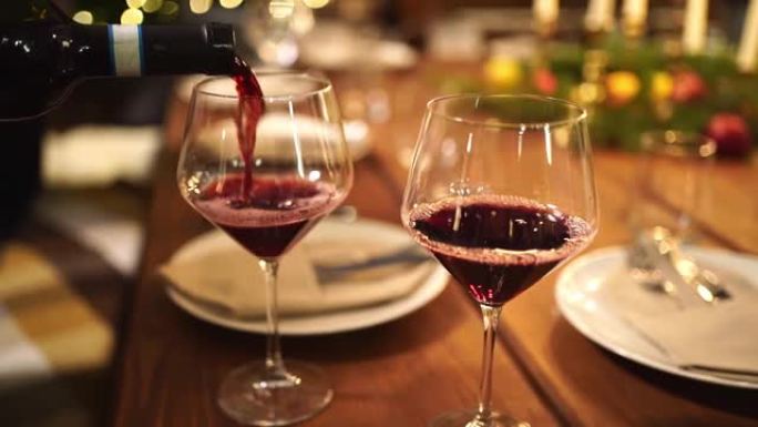 光线不足。在玻璃杯中，用烛光从瓶中倒入葡萄酒作为晚餐。