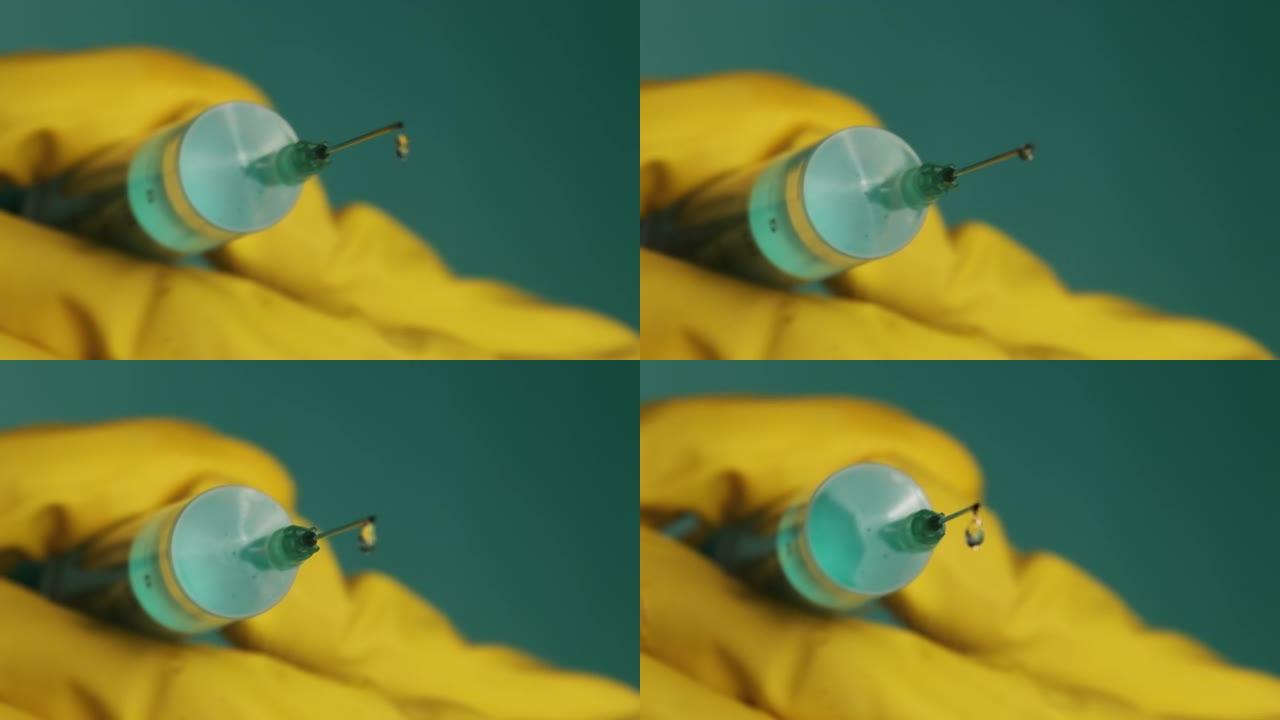 注射器针头与液体滴药在医生手中