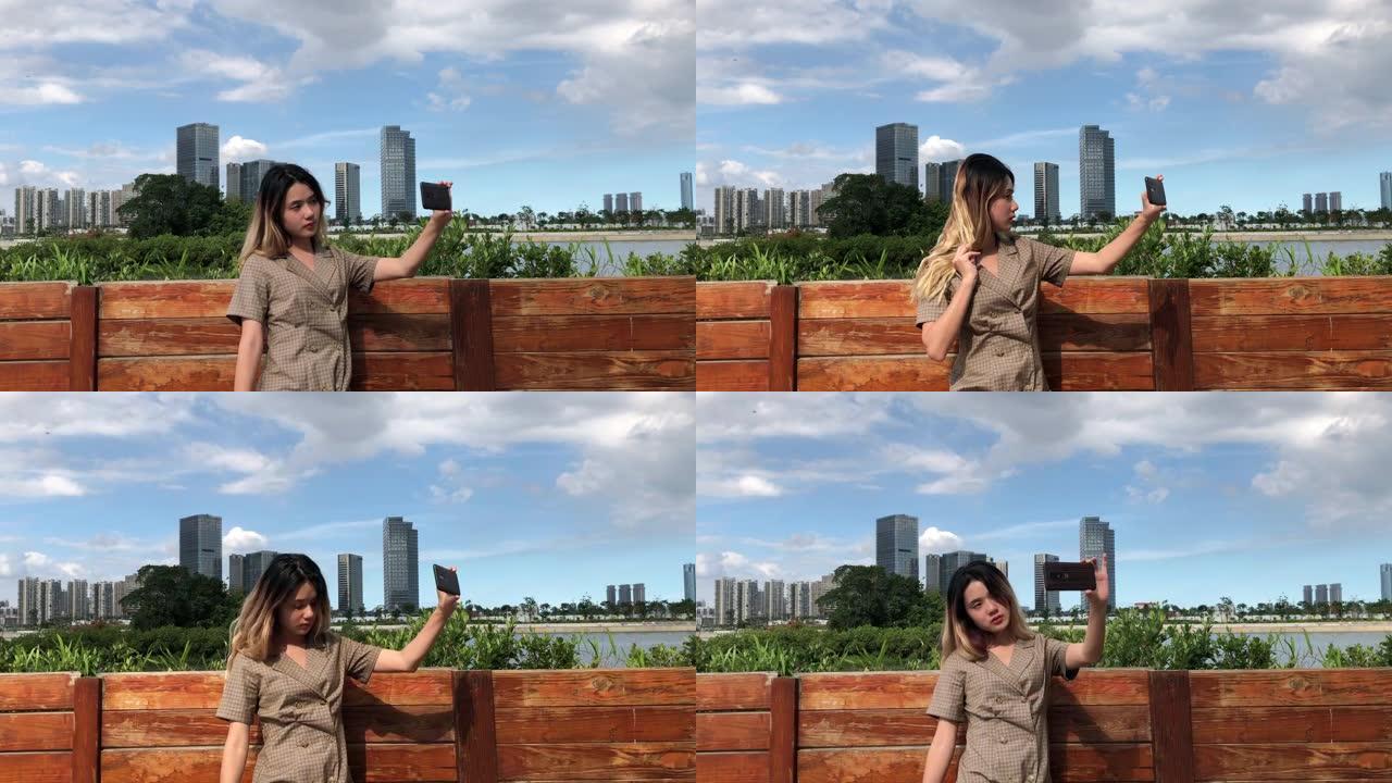 站在外面的中国女孩用相机自拍。