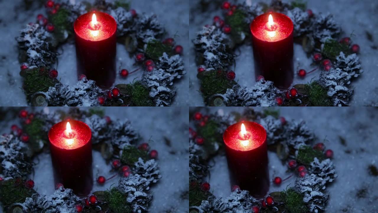 在人造雪的背景下，新年之夜点燃的红色蜡烛
