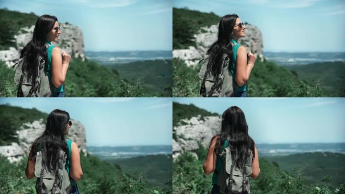 时髦的女性背包在山顶欣赏自然景观。4k Dragon RED摄像机