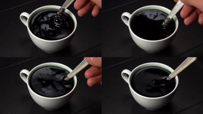 用勺子将叶绿素与水混合在白色杯子中