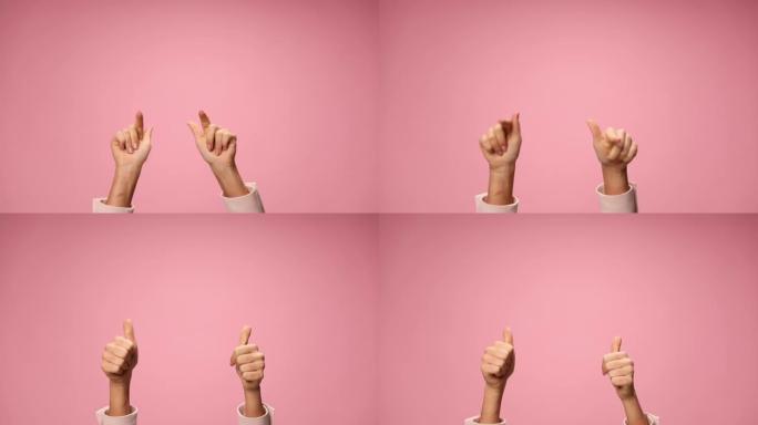 年轻女子双手在空中指着手指，移动，在粉红色背景上竖起大拇指