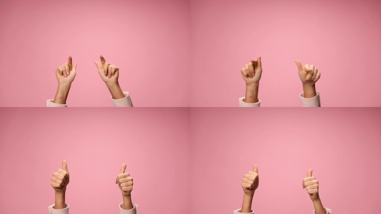 年轻女子双手在空中指着手指，移动，在粉红色背景上竖起大拇指