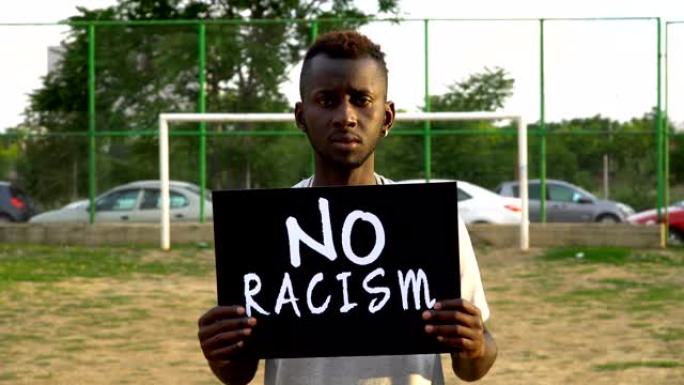 非洲青年抗议者手持纸板“禁止种族歧视”