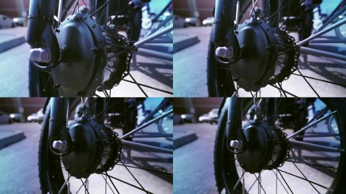 从锐利到模糊车轮和电机的电动自行车视图从下面显示。电动自行车电机摄像机运动滑动特写。停车场有自然照明