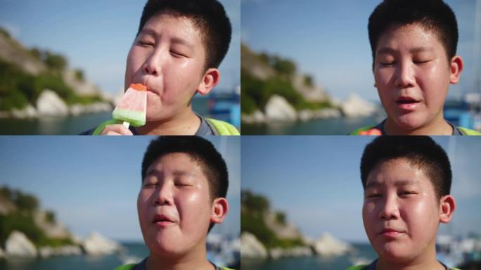 快乐的亚洲背包客男孩在旅途中与阳光明媚的日子一起吃红西瓜冰淇淋，生活方式理念。