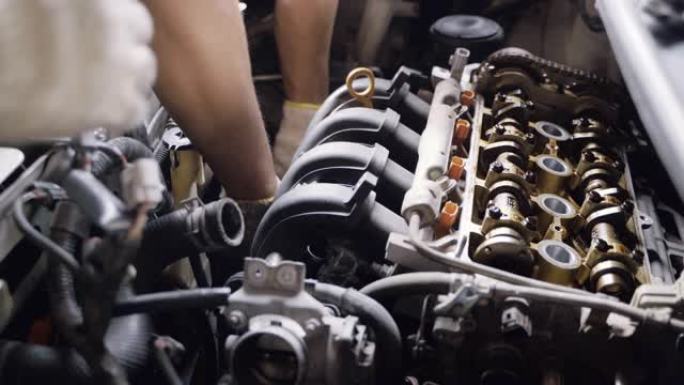 汽车修理工的手协作维修和保养发动机气门气缸体。
