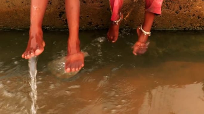 儿童用欢乐夹浸在流动的河水中