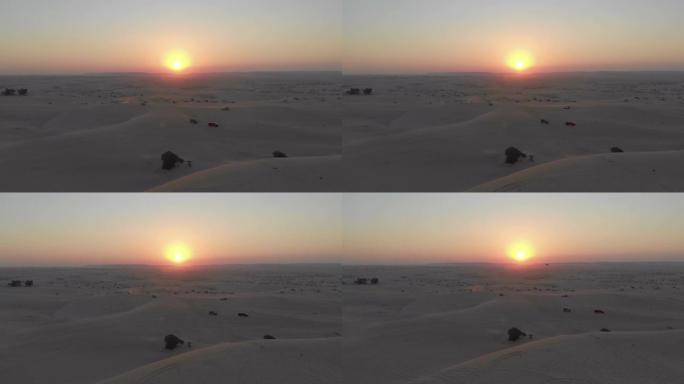 沙特阿拉伯日落时4x4汽车沙丘在沙漠中扑打的航拍画面