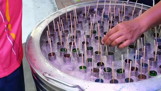 泰国的街头小吃不锈钢水箱里的手捡冰棒棒棒糖