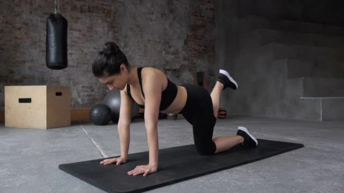 健美操运动锻炼，女性运动者在躺在运动垫上时抬起双腿。