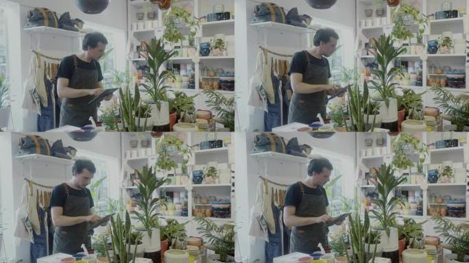 成年工人在他的植物学精品店的数字平板电脑上订购产品
