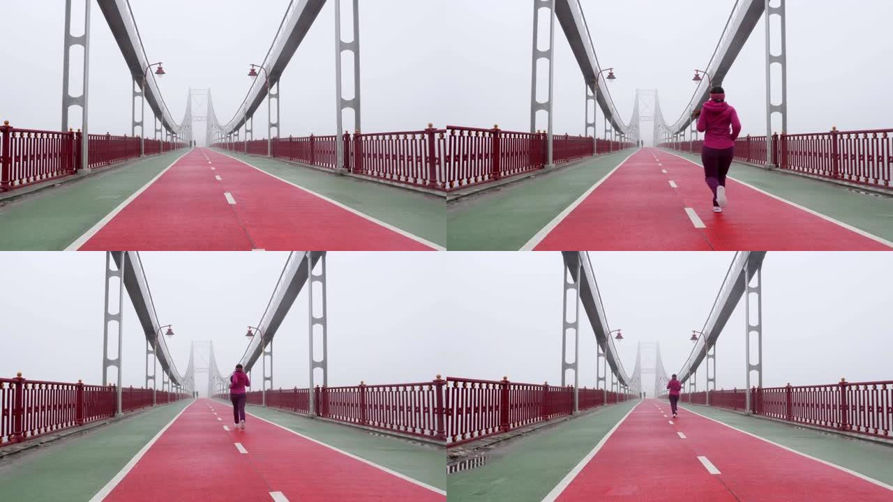 年轻胖乎乎的高加索女孩在桥上奔跑。背部拍摄慢动作。紫色套装