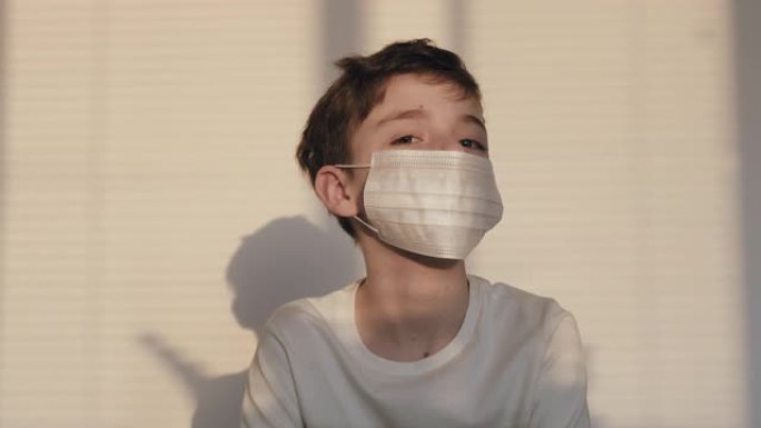 肖像男孩医疗面具面部检疫站在露台房子摇摇头标志在日落灯光。冠状病毒病毒新型冠状病毒肺炎。流行病、肺炎