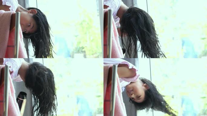 亚洲女孩在家使用靠近窗户的吹风机，生活方式的概念。