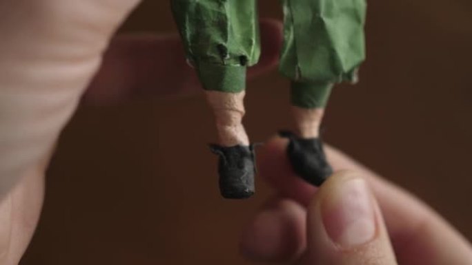 用粘土和纸制成的小雕像男孩小王子脚黑色鞋子