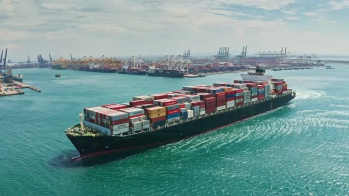 鸟瞰集装箱货船全承运人集装箱前往码头商业港口进行商务物流，进出口，运输或货运。