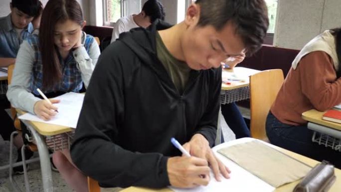 教室里的亚洲学生-冠状病毒大流行后在教室里考试的大学生