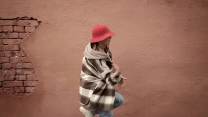 年轻女子嘻哈街舞背景为棕色墙，万向架拍