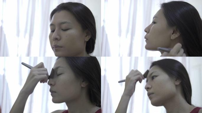 亚洲女性在化妆前先在脸上涂抹粉底